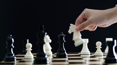 Man hand holding chess knight.